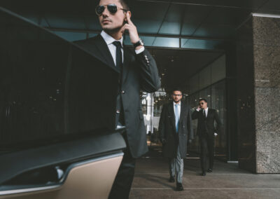 Chauffeur de sécurité ouvrant la portière lors de la prise en charge d’un client protégé, de nuit